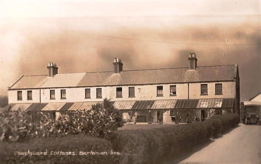 Sepia-toned photo of a row of old cottages with hedges along the front, chimneys on the roof, and writing at the bottom that reads Coastguard Cottages, Barton-on-Sea.
