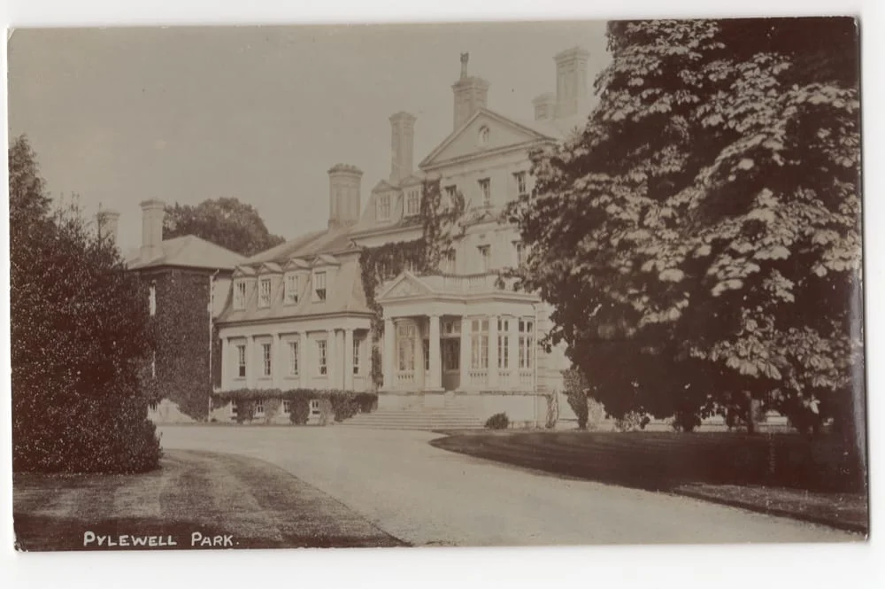 A sepia-toned photograph of a large, elegant mansion with multiple chimneys, surrounded by trees. A curved drive leads to the front entrance. The caption reads Pylewell Park.