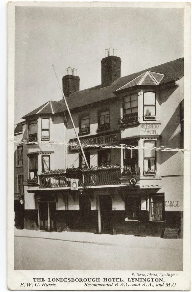 A vintage black-and-white photo of The Londesborough Hotel in Lymington, showing a three-storey building with signs, balconies, and chimneys. Text below lists the hotel name and mentions E.W.C. Harris.