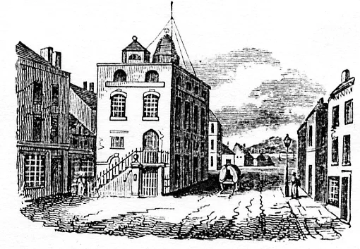 Black and white illustration of the Town Hall 1845 with cobbles, a large multi-storey building with arched windows in the centre, and smaller buildings on either side; a few people and a horse-drawn cart are visible.